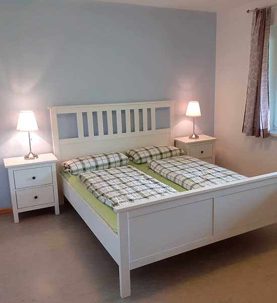 Schlafzimmer mit Doppelbett in der Ferienwohnung Heuboden