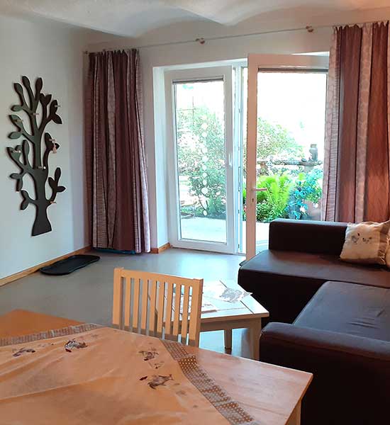 Wohnbereich mit Blick auf die Terrasse in der Ferienwohnung Hühnerstall